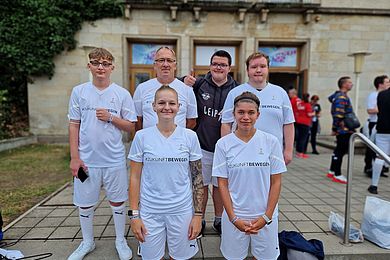 6 Personen mit weißer Sportkleidung stehen auf einer Treppe