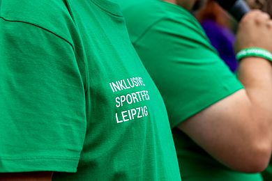 Grünes T-Shirt mit der Aufschrift Inklusives Sportfest Leipzig