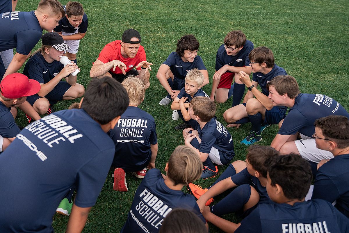 Trainer und Teilnehmende der RB Fußballschule bei einer Teambesprechung