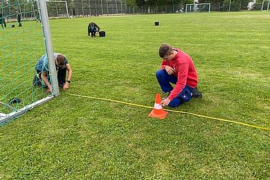 Auszubildender, der ein Fußballtor einmisst