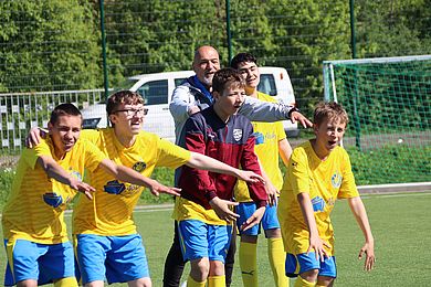 Spieler auf Fußballplatz feuern an
